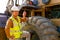 The engineer hold walky talky stand near the tractor and smile to show happy emotion of his work