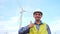 Engineer holding thumb up in front of wind turbines ecological energy industry power windmill