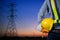 Engineer holding yellow helmet with Transmission tower