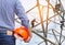 Engineer holding yellow safety helmet with electricians working on pylon construction tower