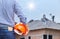 Engineer holding yellow safety helmet at new home building with workers installing concrete tile