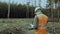 Engineer inspector in forest writes data into planchette about state after logging. Boss chief in hard hat surveys area