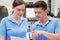 Engineer Instructing Female Apprentice On Use Of CNC Machine