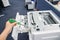 Engineer left hand use green screwdriver repair office printer tray