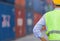 Engineer man in hard hat and safety vest stainding at containers cargo, Factory worker checking containers box