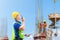 Engineer man in hardhat and safety vest talks on two-way radio, Worker man holding clipboard checklist at construction site