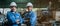 Engineer men wearing uniform safety workers perform maintenance in factory working machine lathe metal.