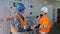 Engineer with papers shows inspector equipment at substation