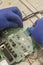 Engineer removes printed circuit board to repair an LCD TV at service center. Selective focus