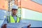 Engineer stand holding schematic paper or blueprints in a container yard