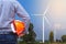 Engineer stand holding yellow safety helmet front wind turbines generating electricity