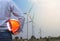 Engineer stand holding yellow safety helmet front wind turbines generating electricity