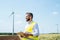 An engineer standing on a field on wind farm, making notes.