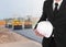 engineer in suit holding helmet with asphalt road under construction