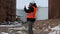 Engineer talking on the smartphone in the factory near to the oil tanks in winter