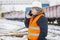 Engineer talking on the smartphone near the freight wagons