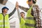 Engineer team and contractor raise their hands up together for joining hands in factory construction building after build success