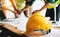 Engineer teams meeting working together wear worker helmets hardhat on construction site in modern city.Asian industry