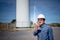 Engineer, technician man working and using  radio communication, with blur of Wind turbines