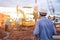 Engineer technician watching team of workers at construction site, Engineer technician Looking Up and Analyzing an Unfinished new