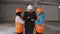 The engineer and two women inspectors on the snow-covered construction site in the winter, inspect the front of the