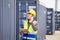 Engineer using smartphone with holding clipboard checklist in industry containers cargo, Foreman dock worker in hardhat and safety