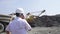Engineer with walkie-talkie directs the loading of heavy dump trucks in a granite quarry slow motion