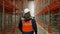 Engineer walks on aisle looking at empty metal racks