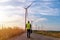 Engineer wearing uniform ,helmet inspection and survey work in wind turbine farms rotation to generate electricity energy. Green e