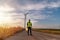 Engineer wearing uniform ,helmet inspection and survey work in wind turbine farms rotation to generate electricity energy. Green e