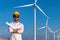 Engineer wearing uniform ,helmet inspection and survey work in wind turbine farms rotation to generate electricity energy. Green e