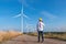 Engineer wearing uniform ,helmet inspection and survey work in wind turbine farms rotation to generate electricity energy. Green e