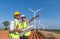 Engineer wearing uniform ,helmet inspection and survey work in wind turbine farms rotation to generate electricity energy. Green e