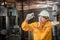 Engineer wearing yellow work clothes white hardhat and wear glove in close up shot holding material with drilling machine.