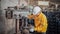 Engineer wearing yellow work clothes white hardhat and wear glove using drilling machine