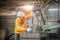 Engineer wearing yellow work clothes white hardhat and wear glove working with drilling machine