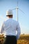 Engineer in wheat field checking on turbine production