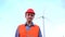Engineer at wind turbine power plant is looking at camera. Portrait of worker