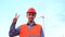 Engineer at wind turbine power plant is showing peace gesture. Wind farm and worker man