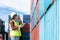 Engineer woman or Foreman manager in container depot working with digital tablet and walkie talkie for control and checking