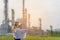 Engineer woman holding blueprint with radio for workers security control at power plant energy and petrochemical industry