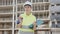 Engineer woman with keys and paper folder in hands standing in construction area and looking in camera.