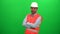 Engineer worker crossing his arms and smiling on green screen.