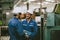 engineer worker male hispanic indian male teamwork happy working together in heavy metal industry steel lathe CNC factory