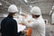 Engineer and worker wearing safety hard hat have meeting on construction site