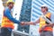 Engineer in Yellow helmet and best greeting with warm handshake manager visiting site. Modern construction and engineering concept