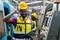 Engineering male african american happy smiling workers wear soundproof headphones and yellow helmet holding tablet working at