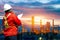 Engineering man with white safety helmet standing in front of oil refinery building structure in heavy petrochemical industry, Eng