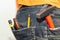Engineering work tool in the back pocket of the jeans. pencil screwdriver hammer and utility knife