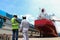 Engineering Workers planning hand holding blue print of the commercial ship standing on floating dry dock yard